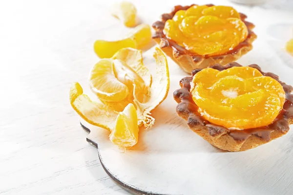 Gâteaux sucrés avec mandarines sur la table, gros plan — Photo