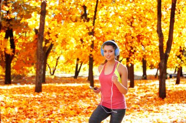 Sonbahar parkında koşan kadın 