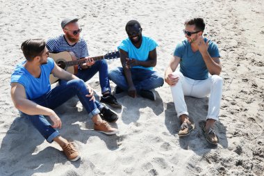 kum üzerine oturan adam