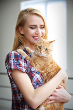 Genç kadın kırmızı kedi ile poz