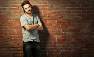 Kulaklıkla müzik dinleyen genç adam. 