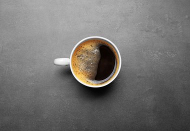 Gri arka planda bir fincan kahve, üst manzara.