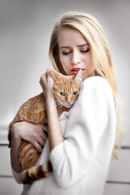kadın kırmızı kedi elinde tutar.