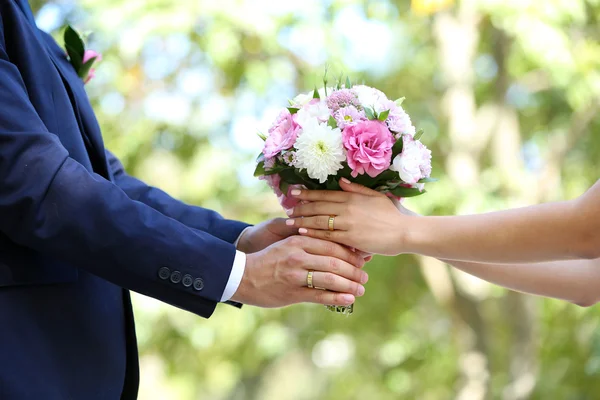 Bruid en bruidegom houden boeket — Stockfoto