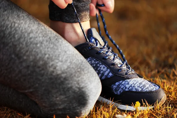 Vrouw in sportkleding koppelverkoop schoenveters — Stockfoto