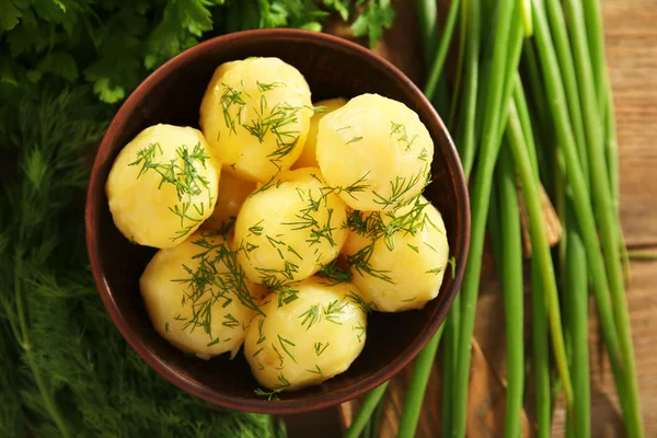 Gekookte aardappelen met Groenen in kom op tafel close-up — Stockfoto