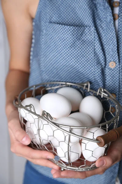 Huevos en cesta en manos de mujer — Foto de Stock