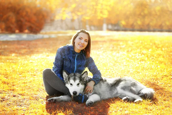 Kvinna sitter med sin hund i park — Stockfoto