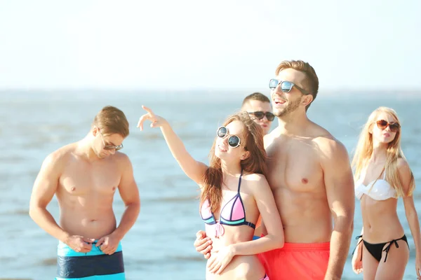 Happy couple and friends relaxing at beach — Stock Photo, Image