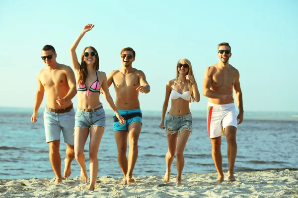 Amigos felices corriendo en la playa —  Fotos de Stock