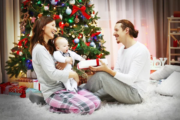 Parents with baby near Christmas tree — Stock Photo, Image