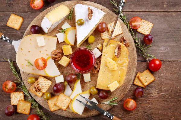 Diferentes tipos de queso sobre fondo de madera — Foto de Stock