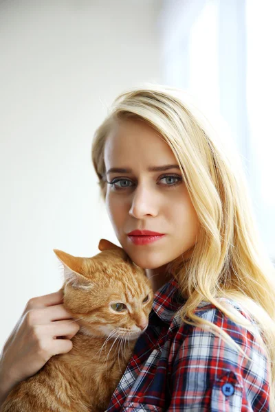 Mladá žena pózuje s červená kočka — Stock fotografie