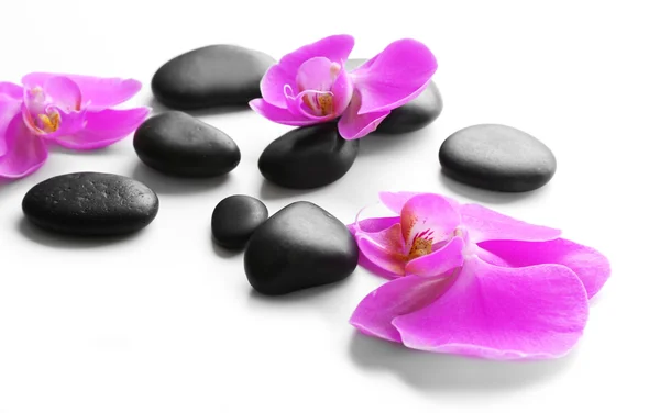 Piedras de spa negro y orquídeas — Foto de Stock