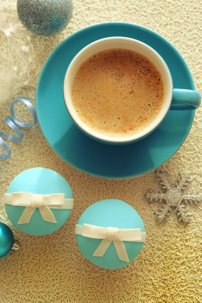 Gâteaux savoureux avec arc, tasse de café et jouets de Noël sur fond en bois de couleur — Photo