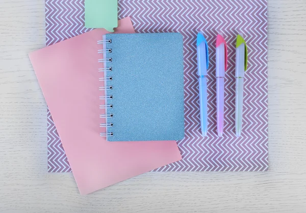 Bolígrafos y cuadernos de colores sobre una mesa —  Fotos de Stock