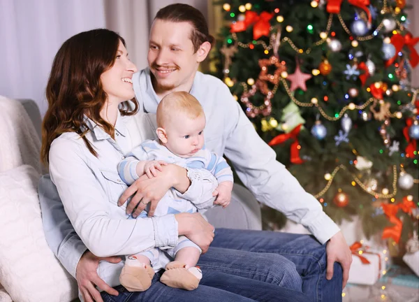 Famiglia felice sul divano nella stanza di Natale — Foto Stock