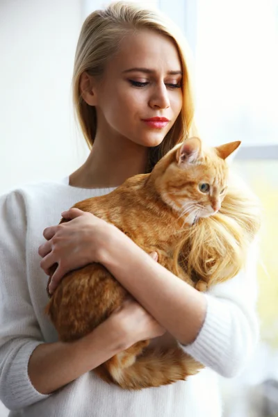 Mulher detém gato vermelho nas mãos — Fotografia de Stock