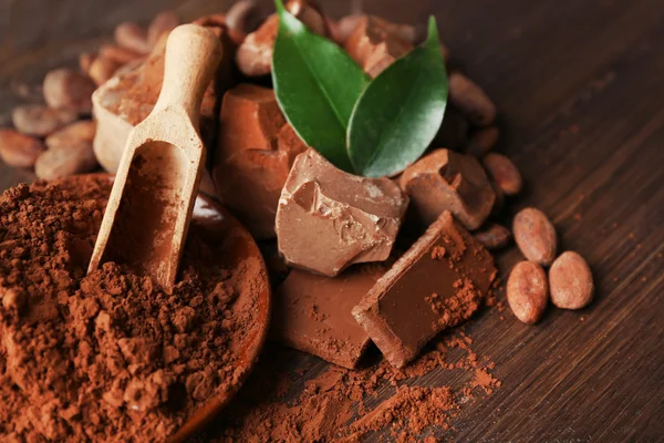 Aromatische cacao en chocolade op houten achtergrond, close-up — Stockfoto