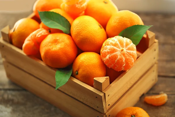 Tangerinas em caixa de madeira, na mesa de madeira velha, close-up — Fotografia de Stock