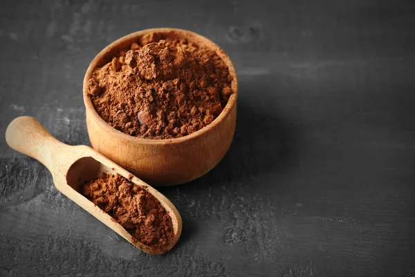 Ciotola con cacao aromatico in polvere su fondo in legno graffiato, primo piano — Foto Stock