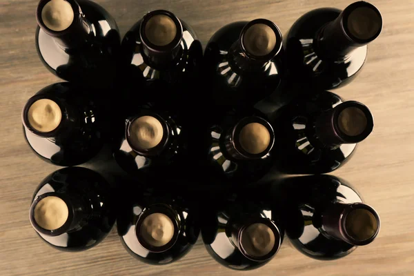 Skleněných lahví vína na dřevěné pozadí, zblízka — Stock fotografie