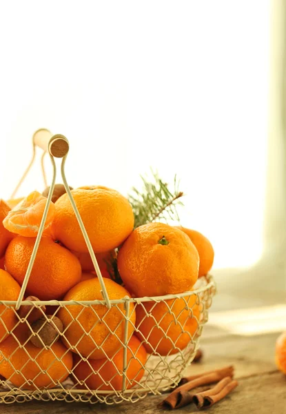 Tangerines in metal basket, on old wooden table, close up — Stock Photo, Image