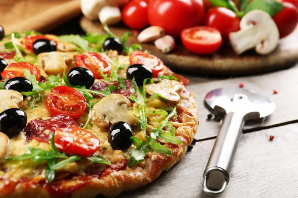 Läckra välsmakande pizza med fräs och ingredienser på träbord — Stockfoto