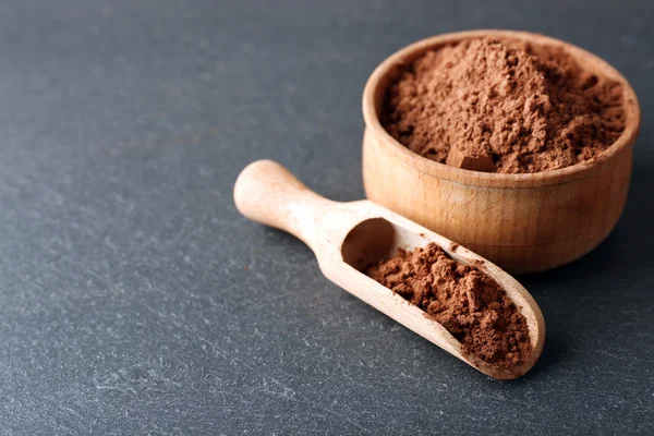 Bol avec poudre de cacao aromatique sur fond gris, gros plan — Photo