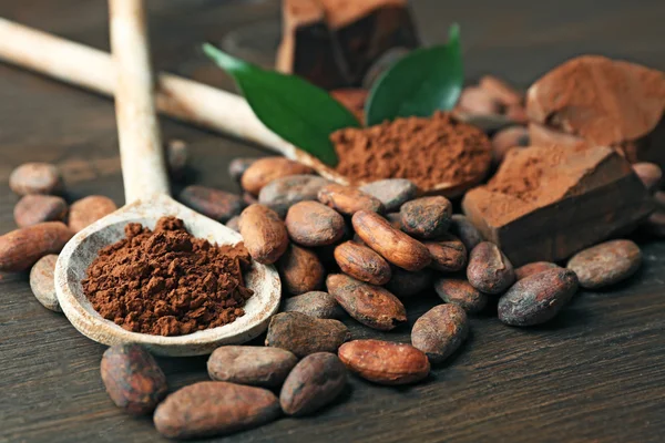 Cuillère avec cacao aromatique et chocolat sur fond bois, gros plan — Photo