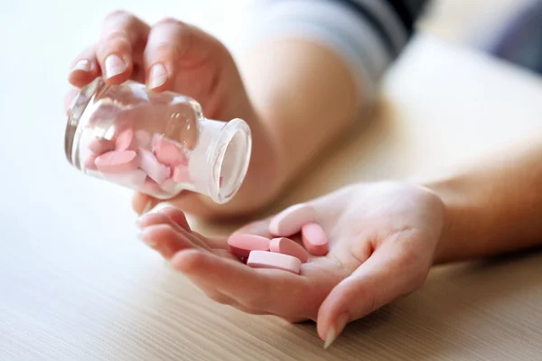 Woman spills pink  medical capsules — Stock Photo, Image