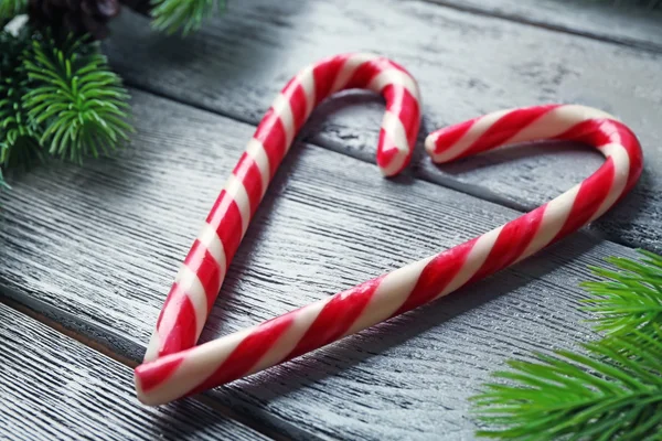Lollipop candies like heart with fir tree branches — Stock Photo, Image