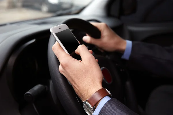 Водитель с помощью смартфона в машине — стоковое фото