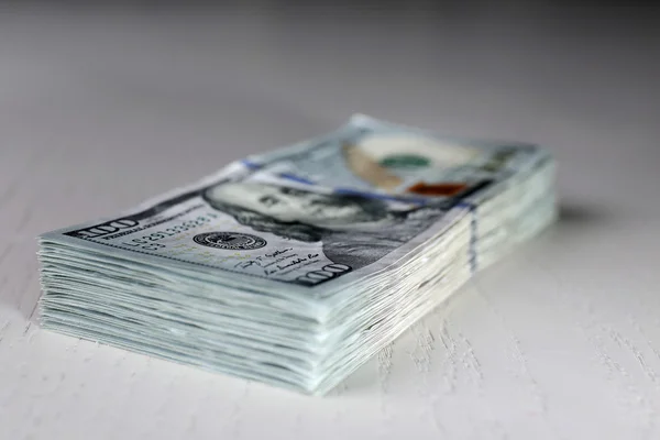 Empilhamento de notas de dólar sobre fundo de madeira clara — Fotografia de Stock