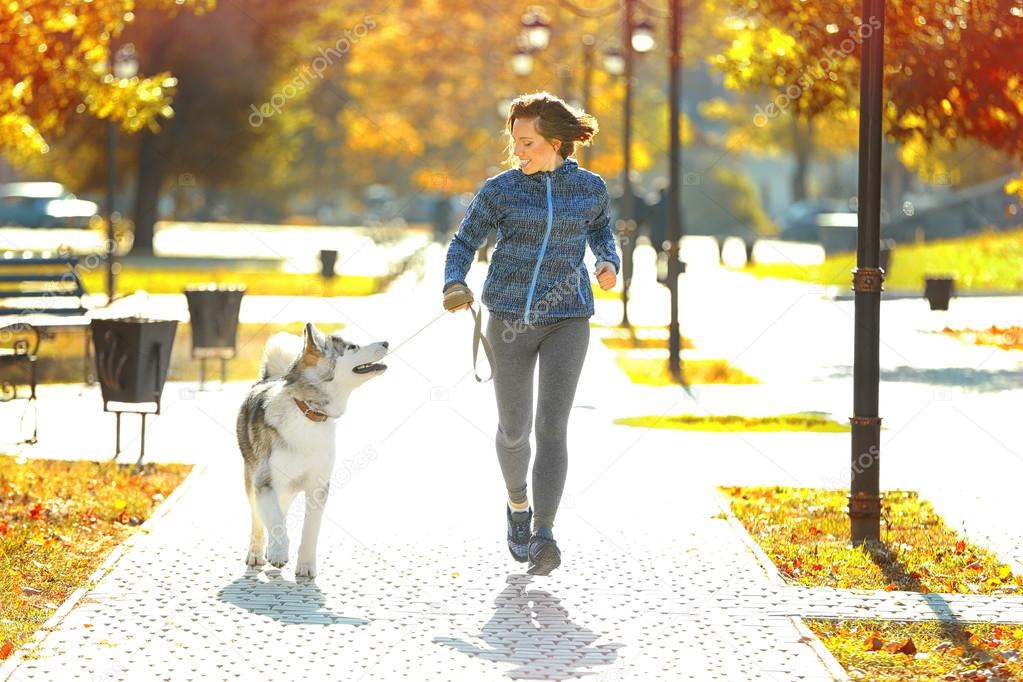 Woman jogging with her dog in park