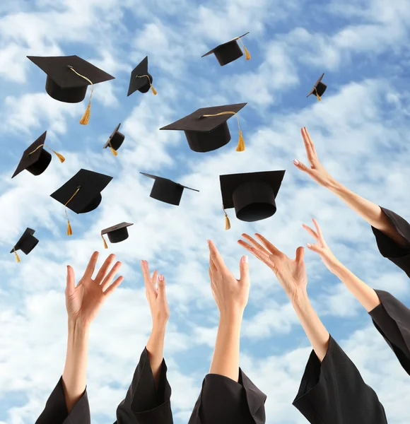 Graduati mani gettando cappelli laurea — Foto Stock