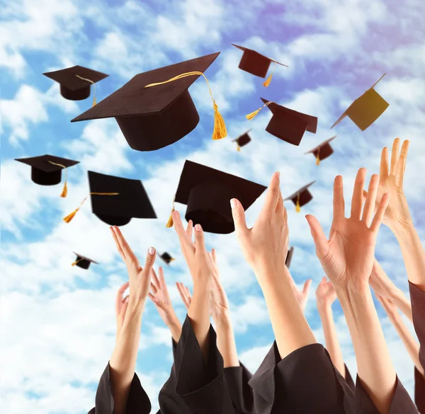 Graduados manos lanzando sombreros de graduación — Foto de Stock