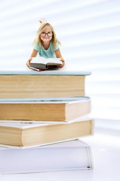 Sevimli Küçük Kız Beyaz Izole Kitap Yığını Üzerinde — Stok fotoğraf