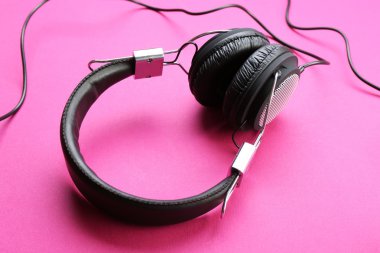 Pembe bir arka plan üzerinde siyah kulaklık