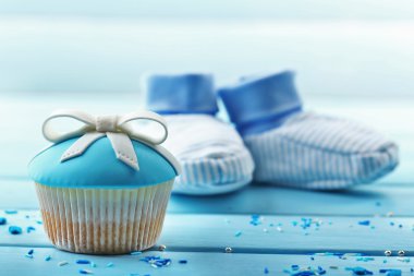 Renk ahşap arka plan üzerinde yay ve bebek ayakkabı ile lezzetli kek