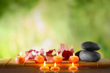 Spa natürmort taşlar, mumlar ve doğal arka plan bulanık su çiçeği.