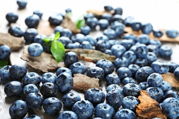 Leckere reife Blaubeeren mit grünen Blättern — Stockfoto