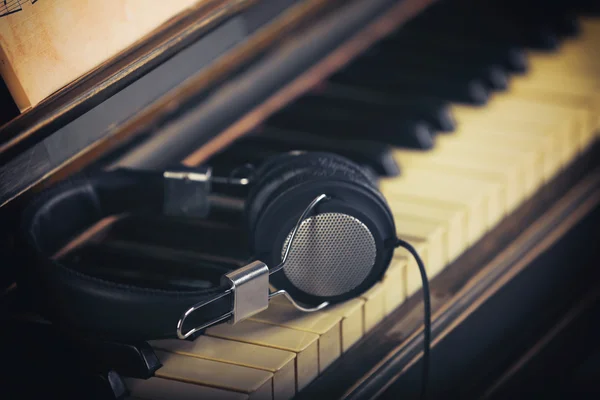 Навушники на клавіатурі піаніно — стокове фото