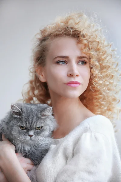 Kvinna och katt på grå bakgrund — Stockfoto