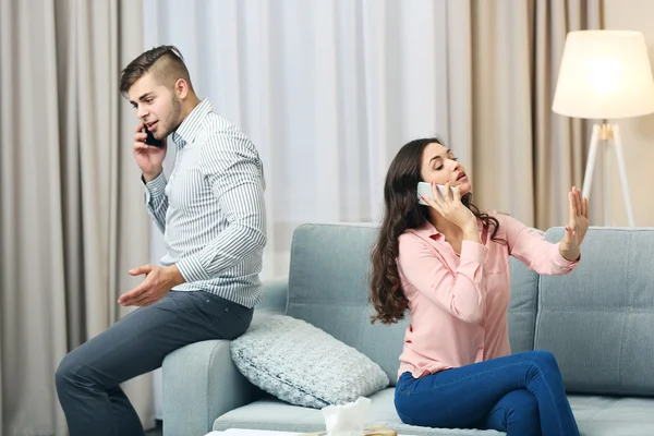 Met mobiele telefoons thuis (echt) paar — Stockfoto