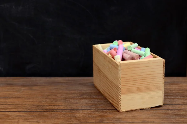 Деревянная коробка с цветным мелом — стоковое фото
