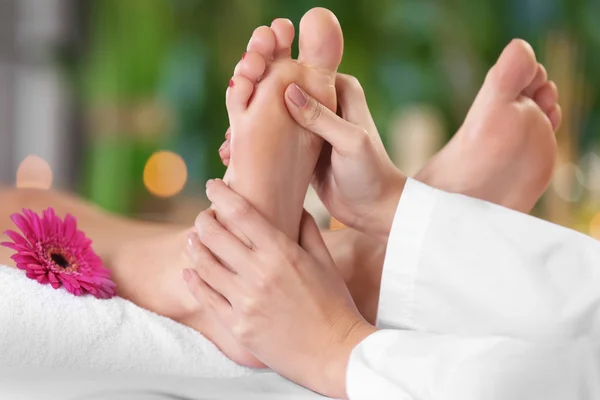 Beautiful young woman relaxing with leg massage at beauty spa — Stock Photo, Image