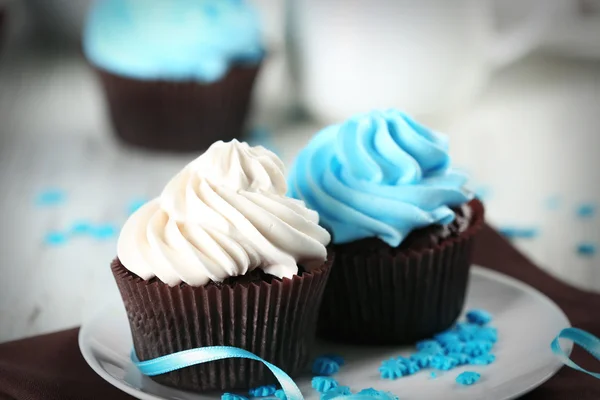 Schokoladen-Cupcakes mit bunter Sahne auf dekoriertem Tisch, Nahaufnahme — Stockfoto