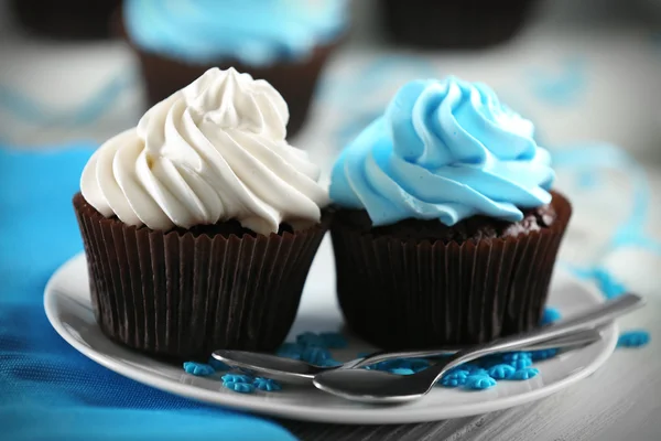 Bolinhos de chocolate com creme colorido na mesa servida, close-up — Fotografia de Stock