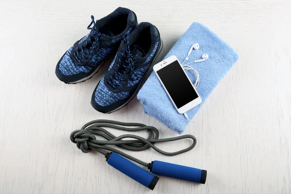 Sport cipő, törölköző és szúró telefon — Stock Fotó